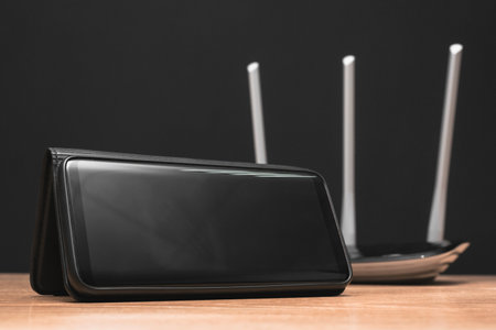 Blank screen mobile phone and wifi router on the table close up.の写真素材