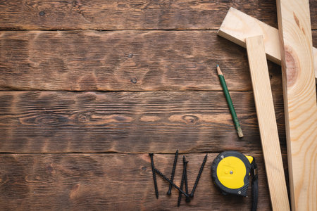 Screws, meter, pencil and wooden bars on the carpenter workbench background flat lay.の写真素材