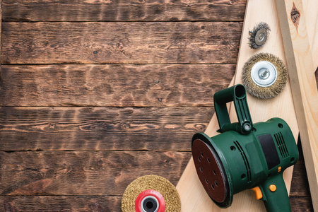 Sanding machine, polishing discs and wooden bars on the workbench background with copy space.