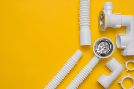 Shower siphon plastic parts on the yellow background with copy space.の写真素材