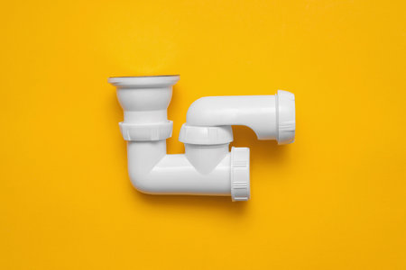 Shower siphon plastic parts on the yellow background with copy space.