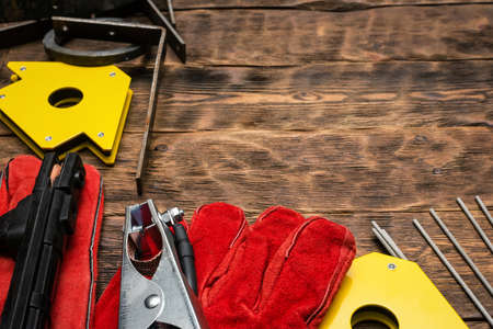 Welding machine, electrods, gloves, magnetic corners and other equipment on the workbench background.の写真素材
