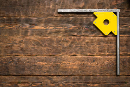 Metal frame with magnetic corner on the brown wooden workbench flat lay background with copy space.の写真素材