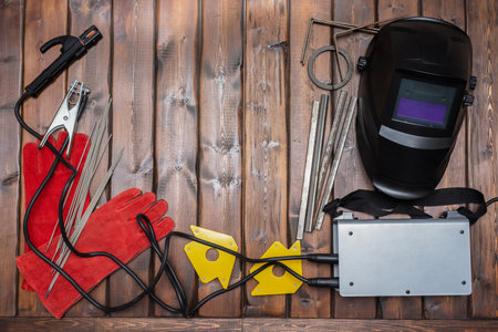 Welding flat lay background with copy space. Welding equipment on the wooden background.