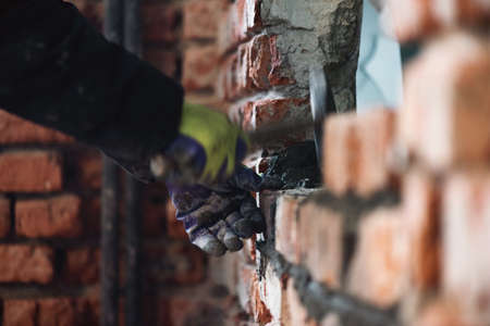 Bricklayer is laying a brick close up.の写真素材