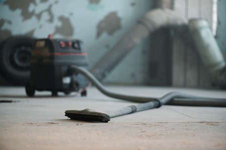 Blurred industrial vacuum cleaner on the dusty floor of construction site.の写真素材