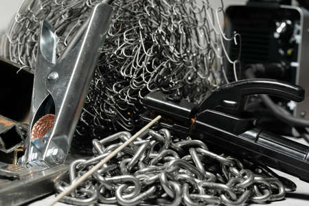 Welding close up concept background. Welding machine terminals and metal pieces on the workbench.