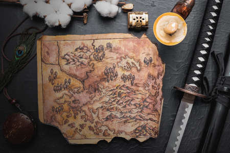 Katana sword and ancient map parchment on the black table background. Samurai way concept.