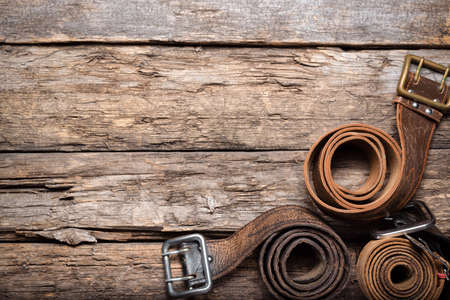 Old retro style male belts on the wooden table flat lay background with copy space.の写真素材