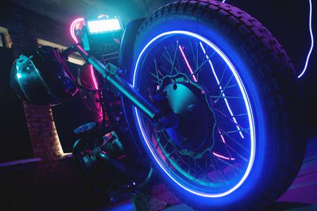 Black motorcycle helmet in the neon lights. Motorbike store showroom concept.の写真素材