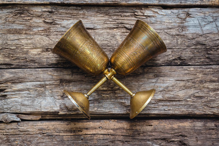 Golden goblets on the old wooden table background. Royal drink concept.の写真素材