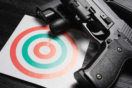 Gun and paper target. Shooting range concept. Shooting practice background.の写真素材