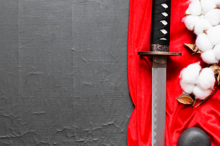 A katana sword on the red cloth on the black table background with copy space.の写真素材