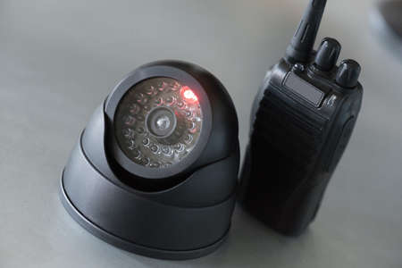 Security camera and walkie talkie radio station on the table close up background.