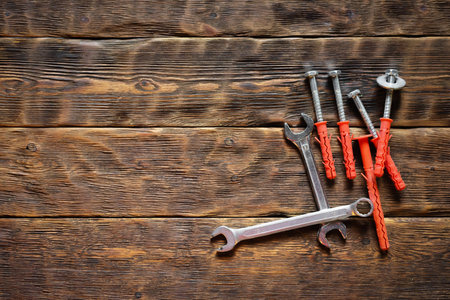 Concrete nails and wrench on the wooden workbench background close up.の写真素材