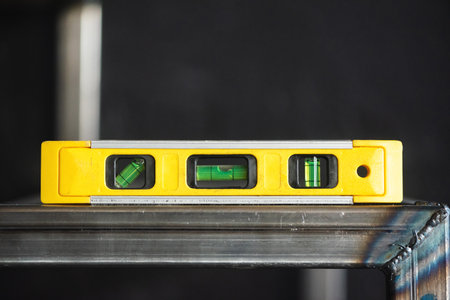 Construction builder level on the metal stairs frame close up background.の写真素材