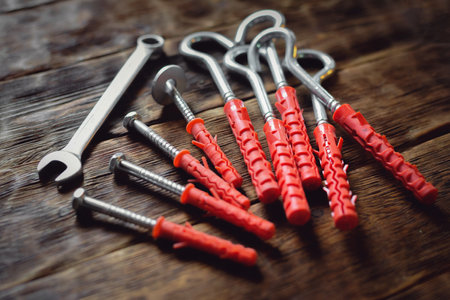 Concrete nails, hook and wrench on the wooden workbench background close up.の写真素材