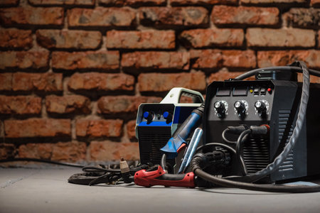 Welding concept background. Semi automatic welding machine and plasma cutter close up on the floor background with copy space. Metalwork concept.の写真素材