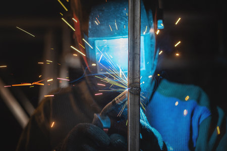 Welder is welding a metal pipes by semi automatic welding.