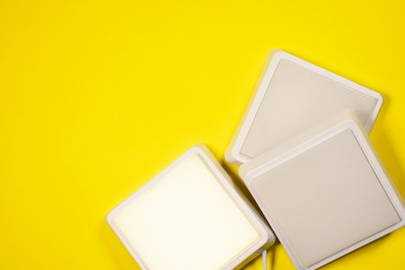 White led square led lamps on the yellow flat lay background with copy space.