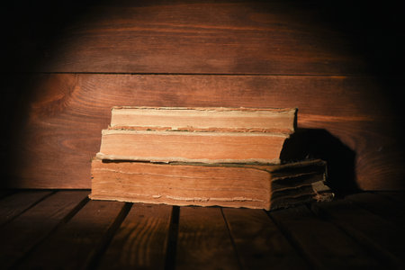 Stack of old books on the wooden desk table background front view.の写真素材