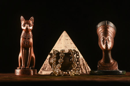 Bust of goddess Bastet and Nefertiti on the table on the dark background.Ancient Egypt concept background. Lost treasure concept.の写真素材