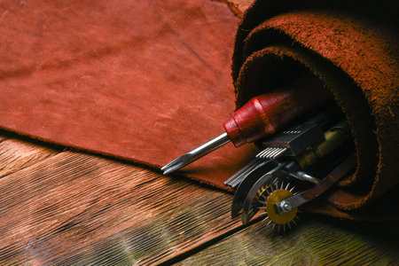 Leather craft work tools and leather on the tanner workbench concept background.の写真素材