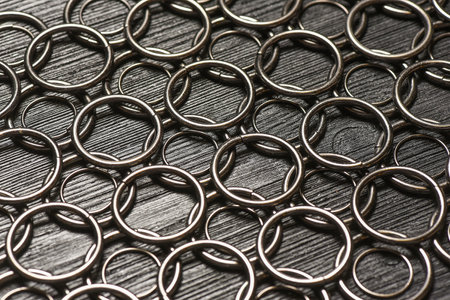 Metal rings for leather craft on the wooden black background. Leather furniture. Top view.