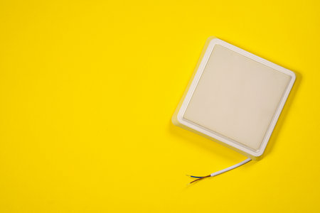 White led square led lamp on the yellow flat lay background with copy space.の写真素材