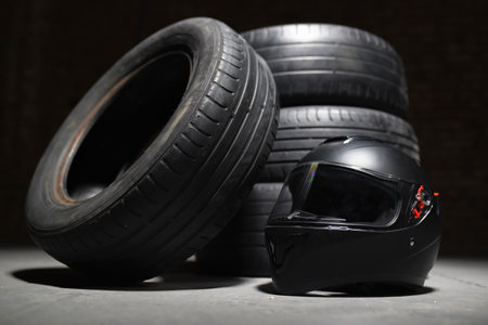 Old used transport car tires and racer helmet on dark background. Motorsport concept. Rally.の写真素材