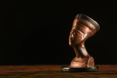 Bust of Nefertiti on the table on the dark background.Ancient Egypt concept background.