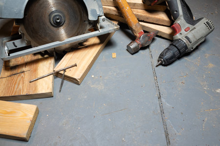 Circular saw, construction tools and wooden boards close up background. Woodwork. Construction site. Home house building.の写真素材