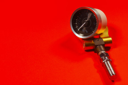 Sport car tow hook and turbine oil pressure sensor on the red background close up.の写真素材