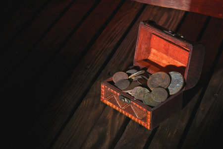 Treasure chest with old coins on the pirate table concept background.の写真素材