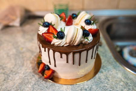 Tasty holiday cake with strawberry on the kitchen table close up.
