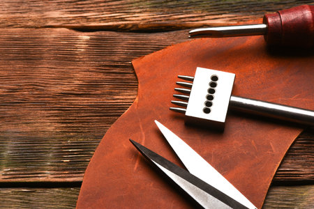 Leather craft work tools and leather on the tanner workbench concept background.の写真素材