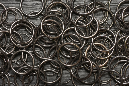 Metal rings for leather craft on the wooden black background with copy space. Leather furniture. Top...