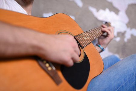 Man playing acoustic guitar close up.