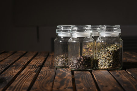 Various types of tea in jars on the table close up front view background.の写真素材