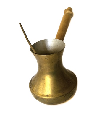 Old copper coffee pot with a spoon isolated on whiteの写真素材