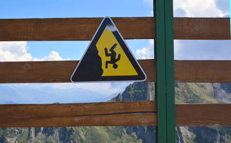 fall warning sign on the fence in the mountainsの写真素材