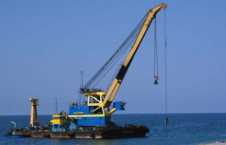 The floating crane on the seashore ready to workのeditorial素材