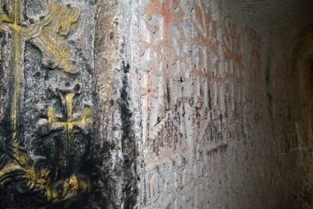 The church wall in the Geghard monastery with dyed and carved crosses. の写真素材
