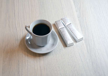 cup of coffee and two chocolates on the tableの写真素材