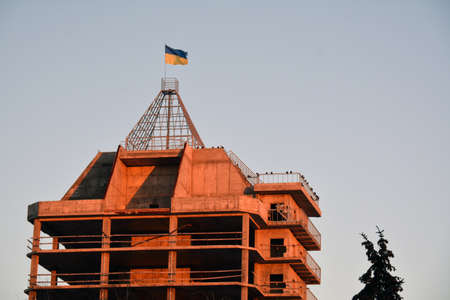 Building with the Ukrainian flag on the sunsetの写真素材
