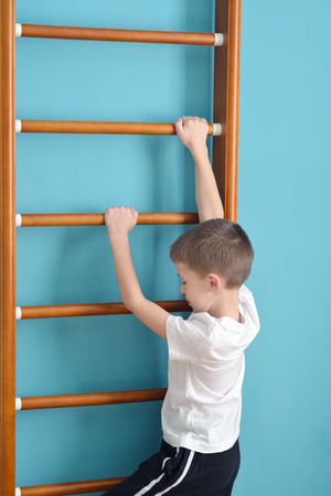 boy climbing a ladder in the gym