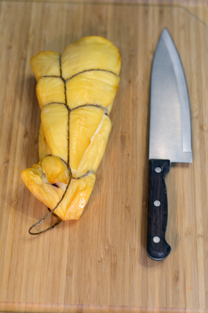 smoked squid on a wooden board with a knifeの写真素材