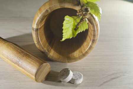 pounder, fresh leaves on it and two tablets on the tableの写真素材