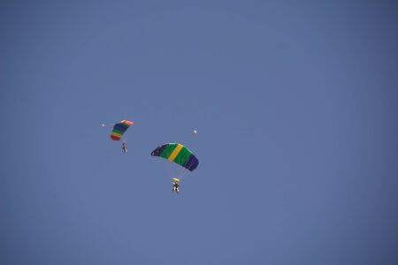 Parachuting people in pairs in the skyの写真素材