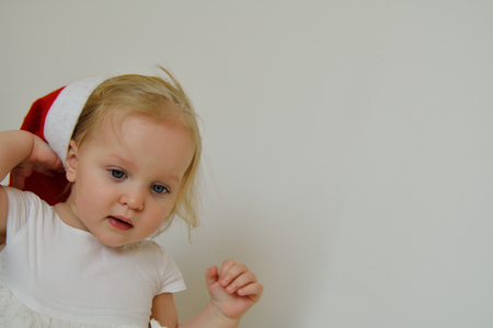 cute blond girl with a red christmas hatの写真素材